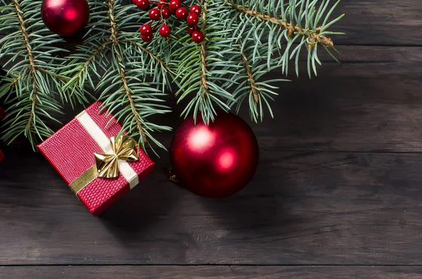 Scatola regalo di Natale rossa con nastro rosso e rami di abete — Foto Stock