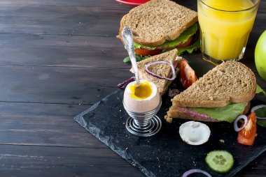  sandviç, yumurta, fincan kahve ve bardak suyu kahvaltı için 