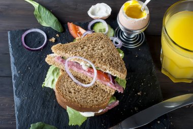  sandviç, yumurta, fincan kahve ve bardak suyu kahvaltı için 