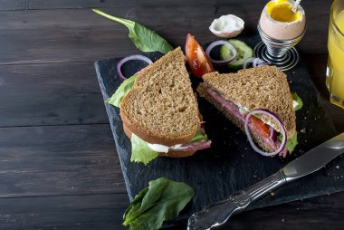  sandviç, yumurta, fincan kahve ve bardak suyu kahvaltı için 