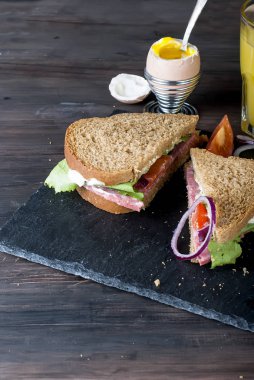  sandviç, yumurta, fincan kahve ve bardak suyu kahvaltı için 