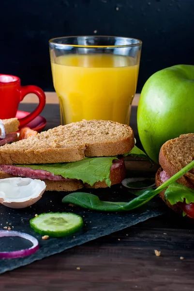 Sándwich, huevo, taza de café y un vaso de jugo para el desayuno — Foto de Stock