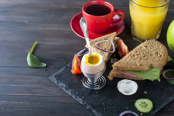  sandviç, yumurta, fincan kahve ve bardak suyu kahvaltı için 
