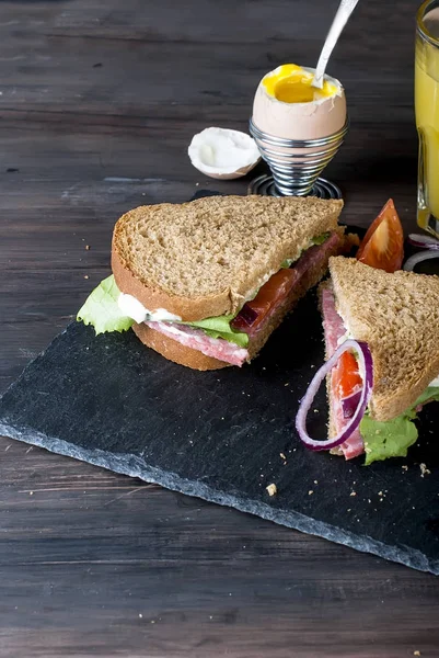  sandviç, yumurta, fincan kahve ve bardak suyu kahvaltı için 