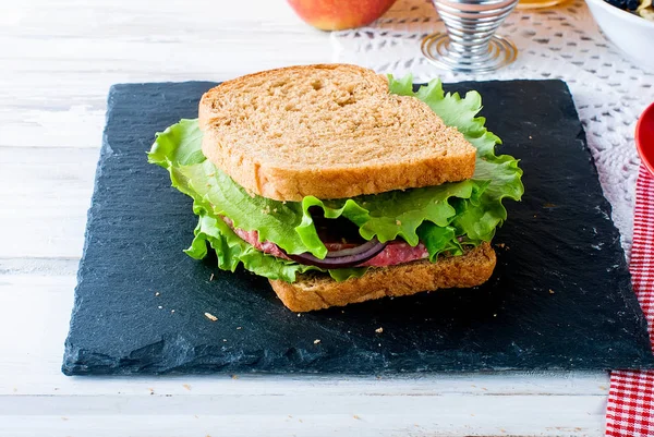 Sanduíche com bacon e legumes sobre fundo branco — Fotografia de Stock