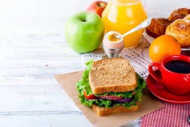  sandviç, yumurta, fincan kahve ve bardak suyu kahvaltı için 