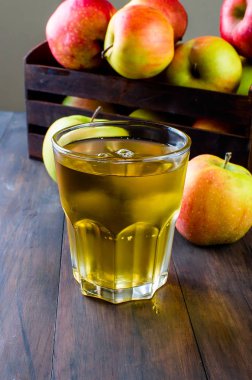 Bir cam ve ahşap bir masa üzerinde bir olgun elma elma suyu