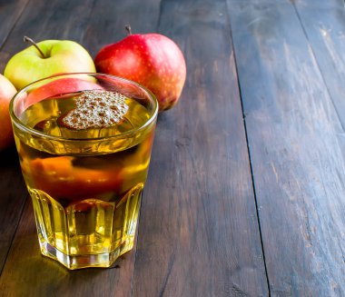 Bir cam ve ahşap bir masa üzerinde bir olgun elma elma suyu