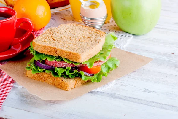 Sándwich, huevo, taza de café y un vaso de jugo para el desayuno — Foto de Stock