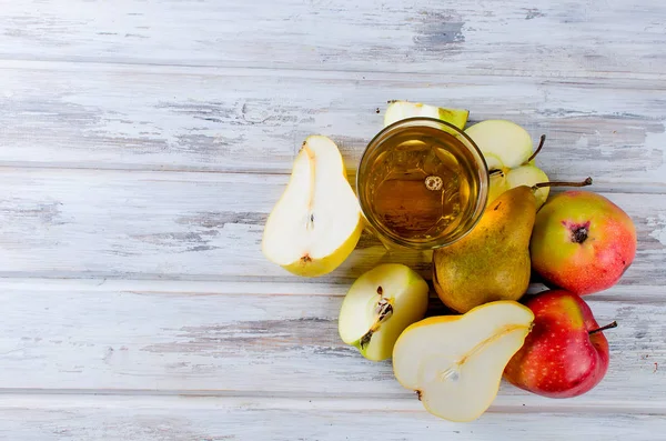 Succo in un bicchiere e mele mature e pere su un tavolo di legno — Foto Stock