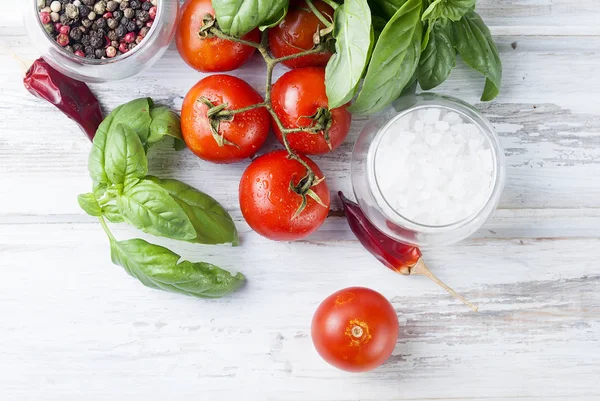 Tomaten en verse groene basilicum op een witte houten CHTERGRO stelletje — Stockfoto