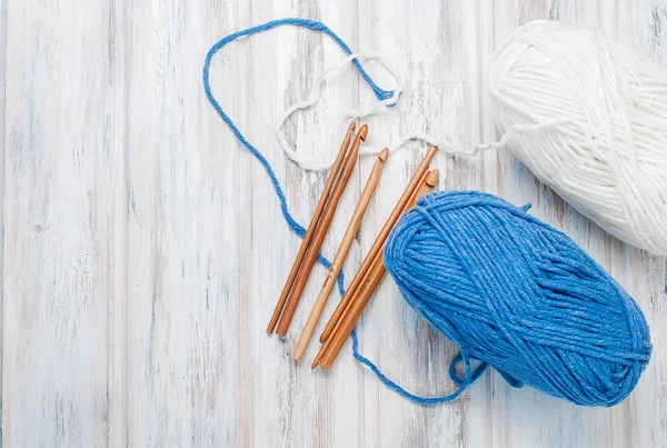 Skeins of yarn and hooks for knitting  on a wooden table. — Stock Photo, Image
