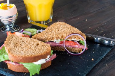  sandviç, yumurta, fincan kahve ve bardak suyu kahvaltı için 