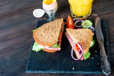  sandviç, yumurta, fincan kahve ve bardak suyu kahvaltı için 