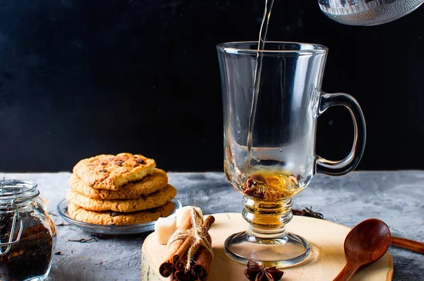 Tasse de thé, biscuits, cannelle, anis sur fond sombre — Photo