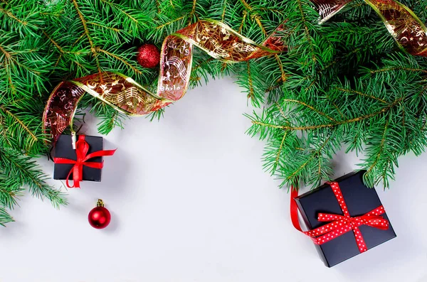 Caixa de presente de Natal preto e vermelho com fita vermelha e farelo de abeto — Fotografia de Stock