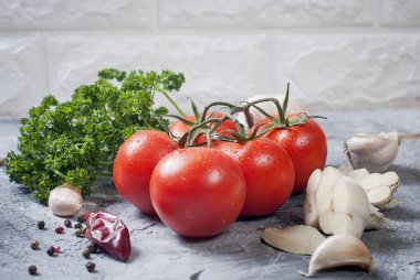 Şube domates ve gri arka plan üzerinde otlar