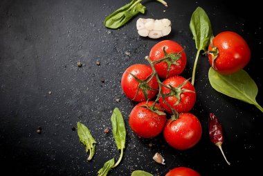 Domates ve otlar dalı ile siyah rustik masa üstü, top vie