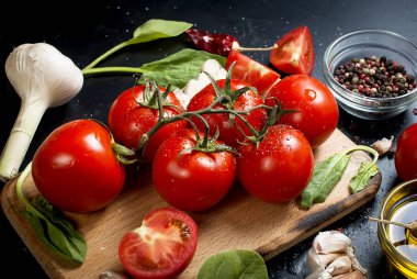 Domates ve otlar dalı ile siyah rustik masa üstü, top vie