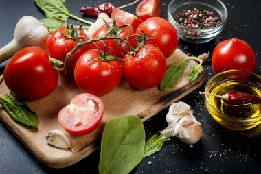 Domates ve otlar dalı ile siyah rustik masa üstü, top vie