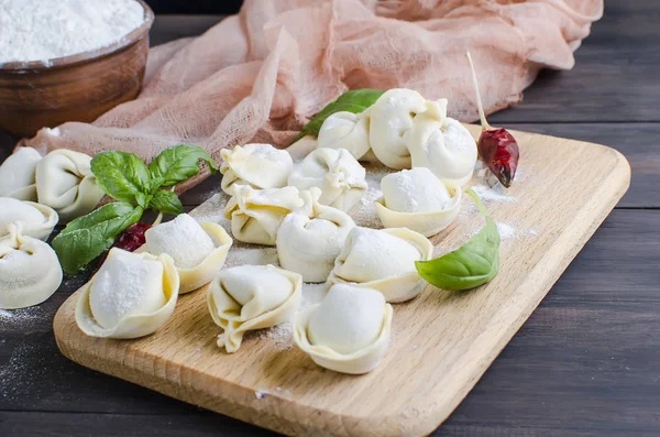 Råa dumplings med kött med mjöl på mörk bakgrund — Stockfoto