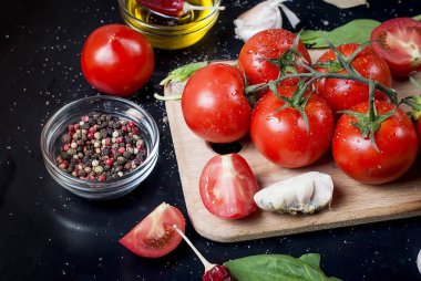 Domates ve otlar dalı ile siyah rustik masa üstü, top vie