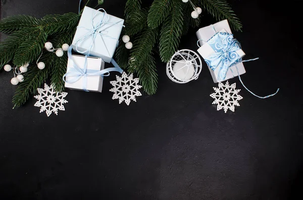 Ramas de abeto de Navidad y cajas de regalos sobre fondo negro . — Foto de Stock