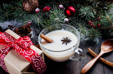 Süt ve tarçın, köknar, koniler ile çay, kırmızı fincan kakao fincan