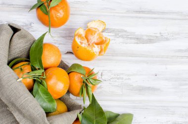 Mandalina clementine ile ahşap bir masa yapraklarda. 