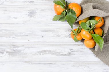 Mandalina clementine ile ahşap bir masa yapraklarda. 