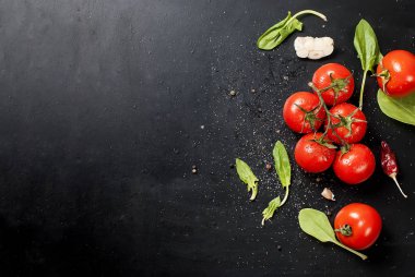 Domates ve otlar dalı ile siyah rustik masa üstü, top vie