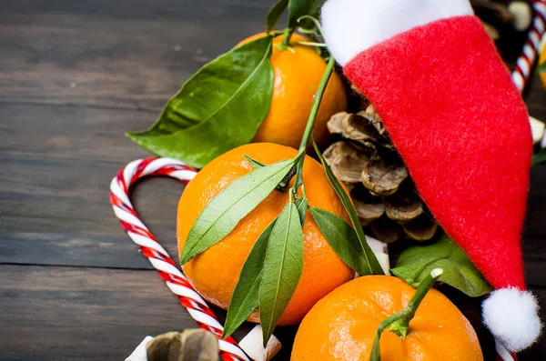 Tangerinas clementina com folhas e brinquedos de Natal em uma madeira — Fotografia de Stock