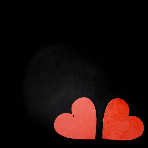 Dois corações de madeira em um fundo preto — Fotografia de Stock