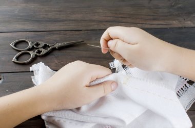 Küçük kızın elleri embroiding çapraz tuval üzerinde.