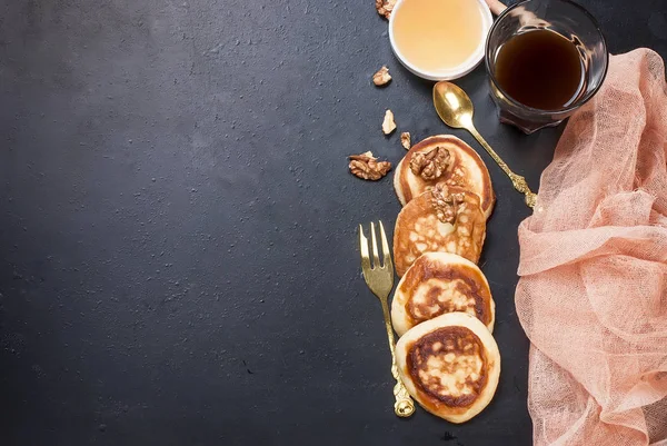 Pancakes with banana, nuts ,honey and cup coffee on dark backgro — Stock Photo, Image