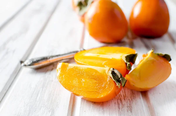 Mogen orange persimoner på ett gammalt träbord — Stockfoto