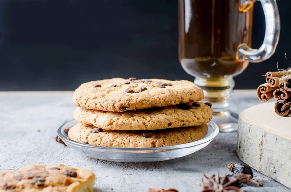 Cookies with chocolate drops, сup of  tea, cinnamon, anise on d — Stock Photo, Image
