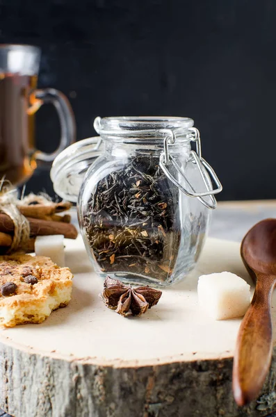 Jar with tea, homemade cookies and  spices for tea on dark   bac — Stock Photo, Image