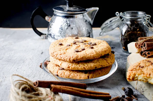 Cookies with chocolate drops, сup of  tea, cinnamon, anise on d — Stock Photo, Image