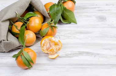 Mandalina clementine ile ahşap bir masa yapraklarda. 