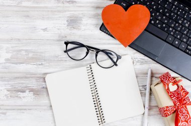 dizüstü bilgisayar, dizüstü bilgisayar ve hediye ahşap masa üzerinde kalp ile