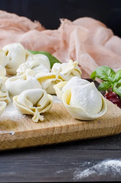 Raw dumplings with meat with flour on dark background — Stock Photo, Image