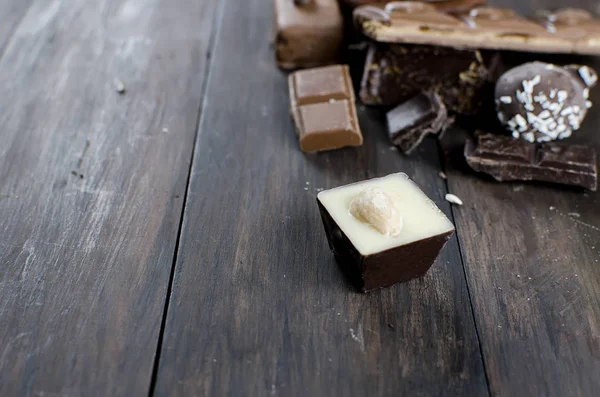 Bitar av choklad på träbord — Stockfoto