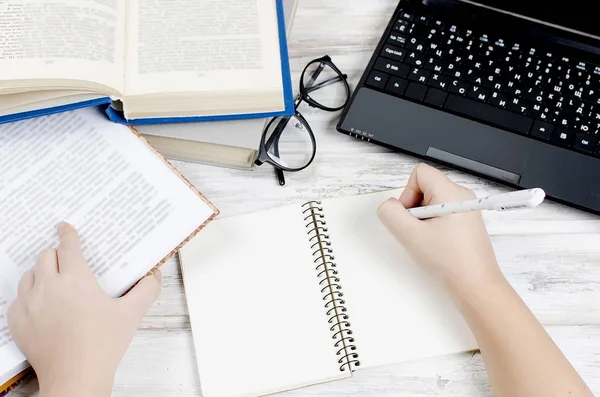 Workplace with laptop,  notepad, pen and books