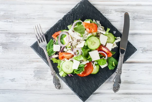 Ein gemischter Salat mit Gurken, Tomaten, Weichkäse, Spinat und — Stockfoto