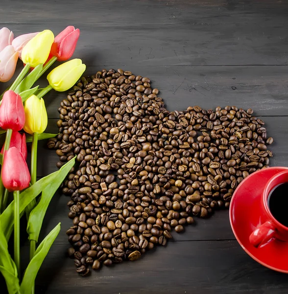 Tasse à café, grains de café et tulipes — Photo