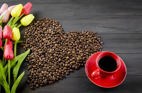 Tasse à café, grains de café et tulipes — Photo