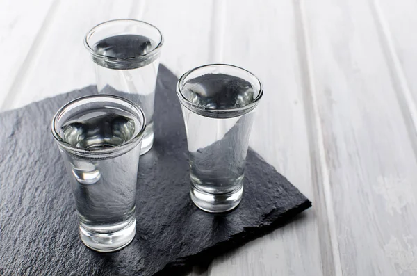 Colpi di vodka sul tavolo bianco — Foto Stock