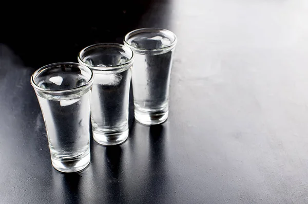 Colpi di vodka sul tavolo nero — Foto Stock