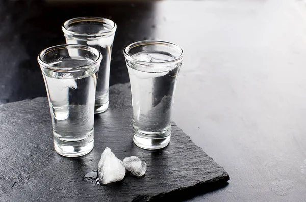 Vodka tiros na mesa preta — Fotografia de Stock